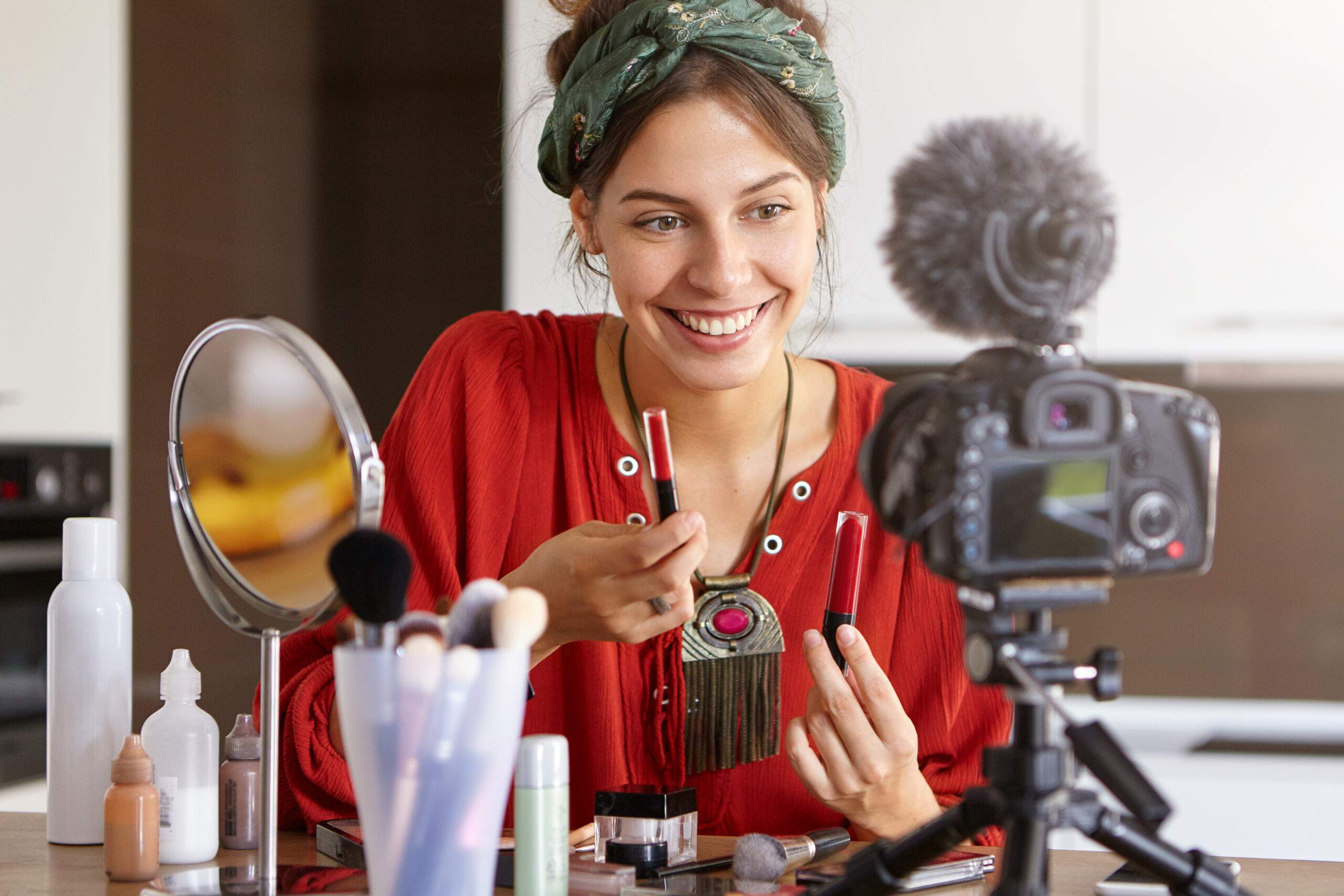 mulher mostra produtos de beleza para uma câmera profissional em um cenário simples